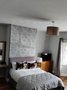 1 dormitorio con 1 cama y una pared grande en Foxhollow House Suite en Blarney