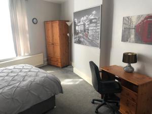 um quarto com uma secretária, uma cama e uma cómoda em 6 Bedroom Villa in Barnsley Centre em Barnsley