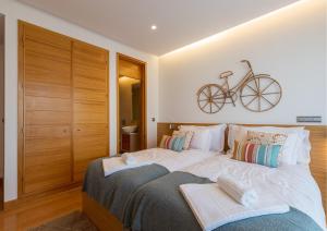 una camera da letto con un letto con una bicicletta appesa al muro di Algarve Vale Lobo Golf&Beach with Private Pool I a Vale do Lobo