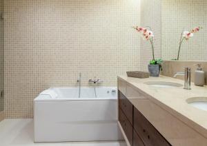 a bathroom with a white tub and two sinks at Algarve Vale Lobo Golf&Beach with Private Pool I in Vale do Lobo
