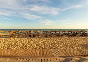 una spiaggia con ombrelloni e sedie e l'oceano di Algarve Vale Lobo Golf&Beach with Private Pool I a Vale do Lobo