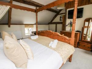 a bedroom with a large bed with white sheets and pillows at The Old Farmhouse in Craven Arms
