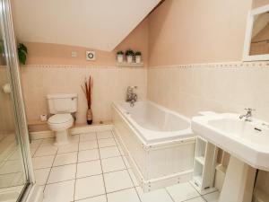 a bathroom with a tub and a toilet and a sink at The Old Farmhouse in Craven Arms