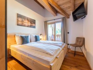 a bedroom with a wooden bed and a chair at AlmApARTment Mauterndorf Pichl 9-4 in Mauterndorf