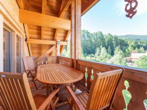a porch with a wooden table and chairs and a window at AlmApARTment Mauterndorf Pichl 9-4 in Mauterndorf