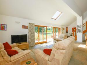 a living room with two couches and a flat screen tv at The Old Parlour in Sampford Courtenay