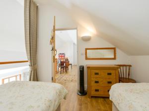 a bedroom with two beds and a dining room at The Old Parlour in Sampford Courtenay