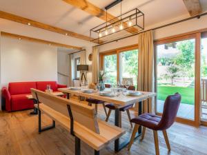 - une salle à manger avec une table et un canapé rouge dans l'établissement AlmApARTment Mauterndorf Pichl 9-1, à Mauterndorf