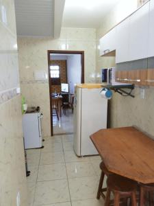 a kitchen with a refrigerator and a table in it at CASA AMARELA in Salvador