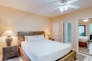 um quarto com uma cama e uma ventoinha de tecto em Palm Beach Club #126 em Pensacola Beach