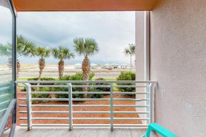 uma varanda com vista para as palmeiras em Palm Beach Club #126 em Pensacola Beach