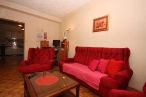a living room with a red couch and two red chairs at Apartments and rooms by the sea Supetarska Draga - Gonar, Rab - 2002 in Supetarska Draga