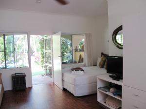 uma sala de estar com um sofá branco e uma televisão em Villa Marine Holiday Apartments Cairns em Yorkeys Knob