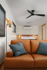 a living room with a brown couch and a bed at Church Lane Accommodation, Milawa. in Milawa