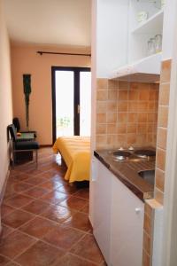 a kitchen with a sink and a room with a bed at Studio Pisak 1070b in Mimice