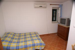 een slaapkamer met een bank en een tv in een kamer bij Holiday apartments Slatine, Ciovo - 4289 in Slatine