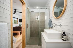 a bathroom with a shower and a sink and a mirror at Church Lane Accommodation, Milawa. in Milawa
