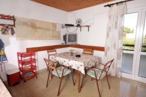 Apartments by the sea Mudri Dolac, Hvar - 4042 في Vrbanj: غرفة طعام مع طاولة وأربعة كراسي