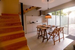 a kitchen and dining room with a table and chairs at Alegria Suítes By Porto City Hosts in Porto