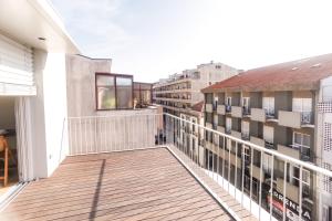 a balcony with a wooden deck and buildings at Alegria Suítes By Porto City Hosts in Porto