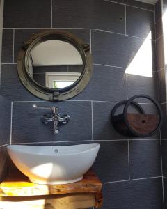 La salle de bains est pourvue d'un lavabo blanc et d'un miroir. dans l'établissement Thuis op Flakkee, à Ooltgensplaat