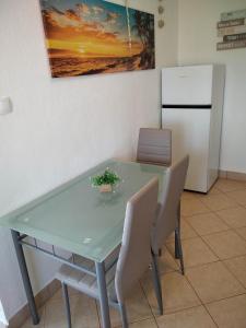 einen Esstisch mit Stühlen und einen Kühlschrank in der Unterkunft Apartments with a parking space Ugljan - 8527 in Ugljan