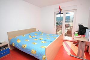 a bedroom with a bed with a blue comforter with sun patterns at Family friendly seaside apartments Slatine, Ciovo - 1096 in Slatine