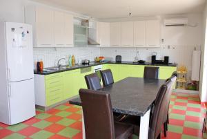 una cocina con armarios verdes, mesa y sillas en Family friendly seaside apartments Slatine, Ciovo - 1096 en Slatine