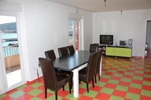 comedor con mesa negra y sillas en Family friendly seaside apartments Slatine, Ciovo - 1096 en Slatine