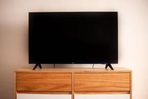 a flat screen tv sitting on top of a wooden entertainment center at Planta Alta BA in Buenos Aires