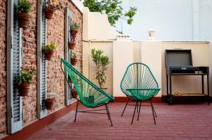 2 Stühle und ein TV auf einer Terrasse in der Unterkunft Planta Alta BA in Buenos Aires