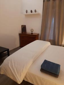 um quarto com uma cama branca e uma toalha azul em B&B Chez Odile em Mirabel