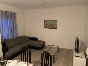 ein Wohnzimmer mit einem Sofa und einem Tisch mit Stühlen in der Unterkunft Apartment Arbanija 1122a in Trogir