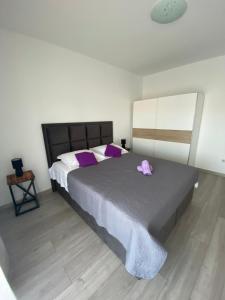ein Schlafzimmer mit einem großen Bett mit einer rosa Blume darauf in der Unterkunft Apartment Arbanija 1122a in Trogir