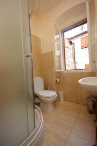 La salle de bains est pourvue de toilettes, d'un lavabo et d'une fenêtre. dans l'établissement Seaside holiday house Komiza, Vis - 3469, à Komiža