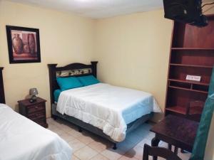 a bedroom with a bed and a book shelf at El Ático Guatemala in Guatemala
