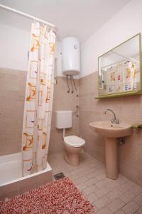 y baño con aseo, lavamanos y cortina de ducha. en Apartments with a parking space Hvar - 4004, en Hvar