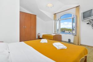 ZastražišćeにあるApartments by the sea Cove Pokrivenik, Hvar - 2073のベッドが2つと窓があるホテルの部屋