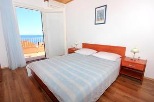a bedroom with a bed with a view of the ocean at Apartments and rooms by the sea Mandre, Pag - 3557 in Kolan