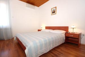 a white bedroom with a bed and a wooden floor at Double Room Mandre 3557a in Kolan