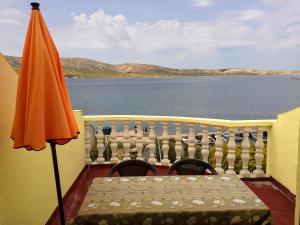 an orange umbrella and a table on a balcony with water at Apartment Zubovici 4125d in Zubovići +15 photos
