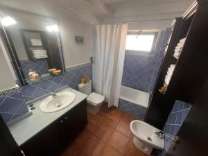 bagno piastrellato blu con lavandino e servizi igienici di Casa Canleyy a Los Llanos de Aridane