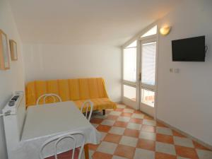 Cette petite chambre comprend une table et un canapé. dans l'établissement Family friendly apartments with a swimming pool Vodice - 4235, à Vodice