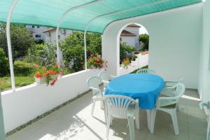 une table et des chaises sur un balcon avec une table bleue dans l'établissement Family friendly apartments with a swimming pool Vodice - 4235, à Vodice