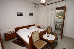 a bedroom with a bed and a table and chairs at Apartments and rooms by the sea Slano, Dubrovnik - 2178 in Slano
