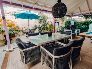 a dining room with a table and chairs and an umbrella at Summer House Inn San Andres in San Andrés +74 photos