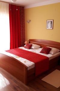een slaapkamer met 2 bedden en een rood gordijn bij Studio Supetarska Draga - Donja 2022b in Rab