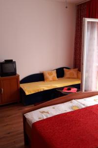 een kleine kamer met 2 bedden en een televisie bij Studio Supetarska Draga - Donja 2022b in Rab
