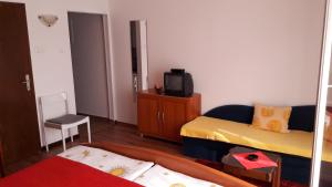een kleine kamer met een bed en een televisie bij Studio Supetarska Draga - Donja 2022b in Rab