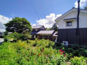 um jardim em frente a uma casa com flores em Echizen Guesthouse TAMADA em Fukui